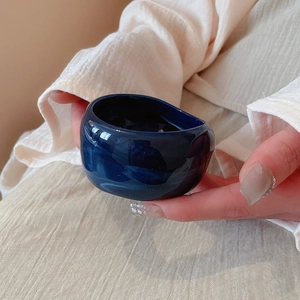 Macro detail of wide deep blue marble resin bangle with a polished glossy finish