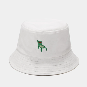 Close-up of a white cotton bucket hat featuring a green frog embroidery and stitched brim