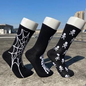 Détail de chaussettes mi-hautes en coton avec motifs tricotés de toile d'araignée et crâne