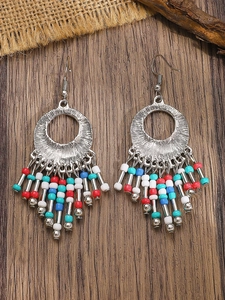 Detail of Bohemian tassel earrings with colorful beads and silver engraved metal disks