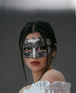 Détail macro d'un demi-masque gris argenté vintage avec textures gravées baroques