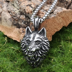 Detailed relief of punk wolf head pendant on tree bark background with a thick chain