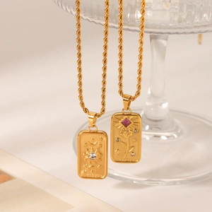 Detail of tarot card necklaces with Sun and Lovers embossed pendants in gold
