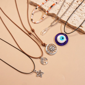 Detail view of vintage charms including evil eye, sun, moon and bohemian beaded necklaces