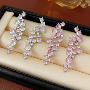 Close-up of irregular zircon tassel earrings in white and pink crystals on black foam