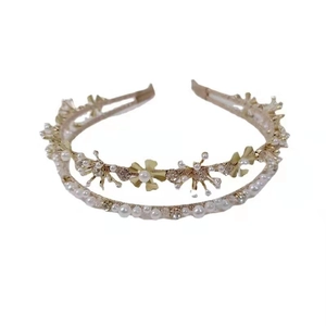 Detail of double-layer gold headband with metal flowers and white pearls