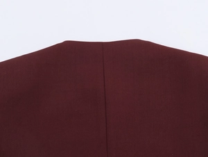 Close-up of dark red tweed blazer fabric showing refined texture and central back seam