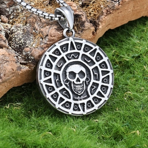 Macro shot of silver viking skull pendant on moss background with ancient symbols