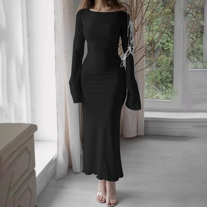 Detail of elegant black bodycon dress featuring white lace-up straps on the long sleeve