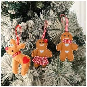 Détail de suspensions renne et bonhomme en pain d'épice en feutre sur un sapin de Noël enneigé