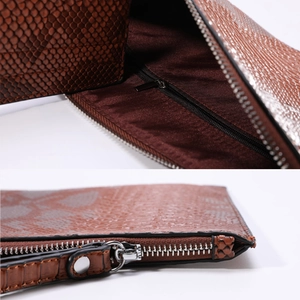 Macro detail of the brown snake pattern texture and interior lining with zipper pocket