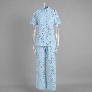 Detailed close-up of light blue floral lace fabric on short sleeve button shirt and pants