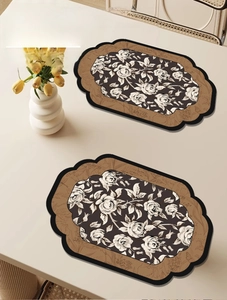 Detail of vintage waterproof leather placemats featuring black and white floral rose patterns