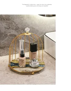 Detail of birdcage cosmetic organizer with gold metal frame and marble-effect base