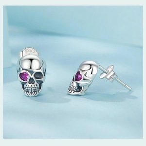 Macro shot of S925 sterling silver skull stud earring with pink heart zircon eye