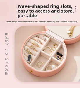 Macro view of portable jewelry box showing wave-shaped ring slots and inner velvet lining