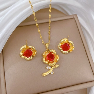 Luxurious gold flower jewelry set with red gemstones and crystals in a beige gift box