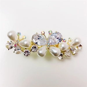 Elegant butterfly hair clip with white pearls and sparkling crystals on gold metal base