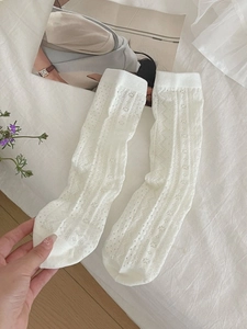Detailed view of white lace hollow pattern with floral mesh on women's crew socks