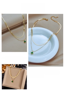 Detail of gold double-layer chain necklace featuring a square green zircon pendant