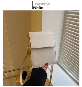 Detail of a white crossbody bag with fine leather texture and minimalist flap closure