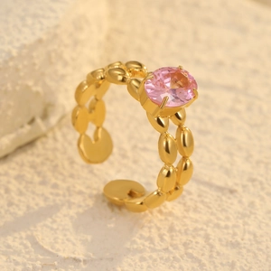 Dettaglio di un anello dorato regolabile a catena con una pietra di zircone rosa tonda