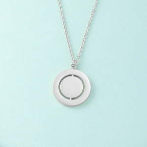 Detail of a rotating geometric silver necklace with a double-layered pendant design