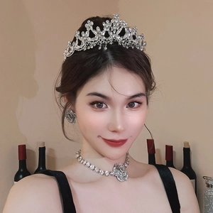 Detailed view of luxury bridal jewelry set with floral rhinestone necklace and silver crown
