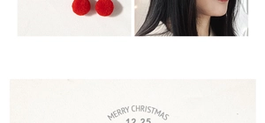 Detail of red plush Christmas hair clip featuring festive pom-poms and holiday motifs