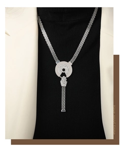 Detail of silver mesh chain necklace with sparkling diamond-encrusted geometric pendant