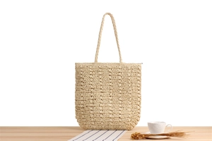 Detailed texture of hand-woven paper rope tote bag on light wood desk with summer decor