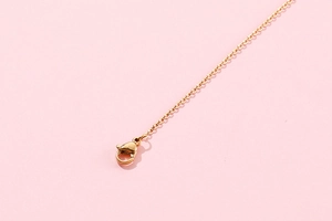 Close-up of golden stainless steel necklace chain featuring a secure lobster clasp