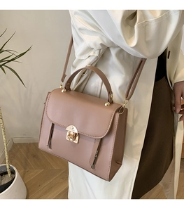 Lifestyle shot of pink-tan leather briefcase bag with gold hardware and top handle
