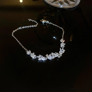 Close-up of silver zircon leaf bracelet with marquise stones on black reflective surface