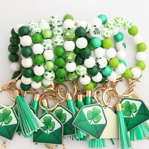 Detail of St. Patrick's Day keychain with green wood beads, shamrock charms and silk tassel