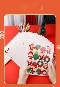 Close-up of colorful Christmas cartoon stickers featuring Santa and trees on a red desk