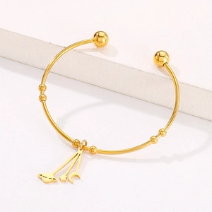 Detail of gold moon and star celestial charms on adjustable stainless steel bangle