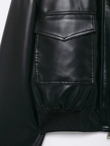 Nahaufnahme der schwarzen Lederjacke mit Tasche, Reißverschluss und geripptem Taillenbund