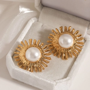 Elegant gold sunflower earrings with pearl centers displayed on a white velvet box