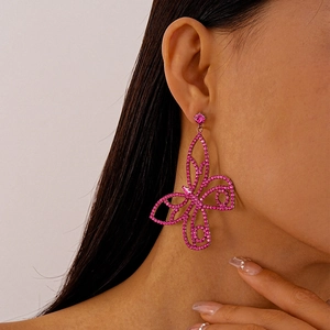 Detailed view of a model wearing a pink rhinestone butterfly earring in a chic style