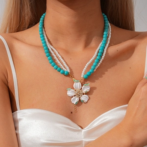 Multi-layer necklace with blue beads, pearls, and a large rhinestone flower pendant