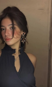 Détail des boucles d'oreilles étoiles avec cristaux marron et noirs portées par le mannequin