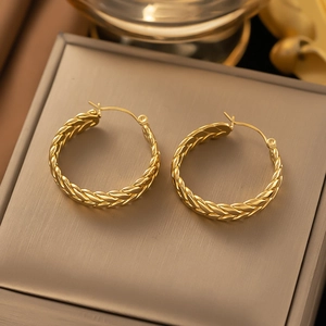 Detailed view of golden woven textured hoop earrings with a premium braided metal finish