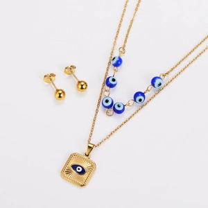 Detail of double-layer gold necklace with blue evil eye beads and square charm set