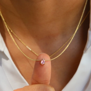 Detail of pink pear-cut zircon pendant on gold-plated stainless steel chain