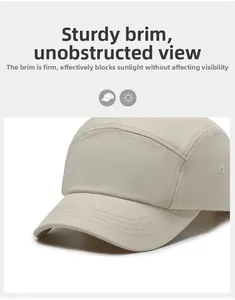 Detail of off-white five-panel cap showing stiff brim stitching and metal air vents
