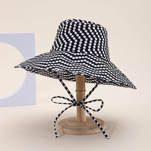 Women's wide brim sun hat with classic black and white polka dot pattern and tie