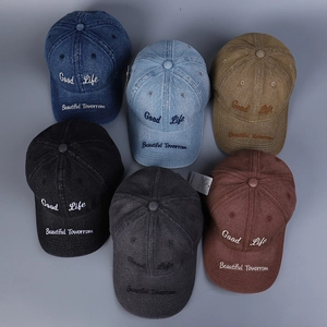 Flat lay of washed denim baseball caps in six colors with Good Life embroidery
