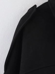 Close-up of black suede bomber jacket shoulder straps and textured fabric detail