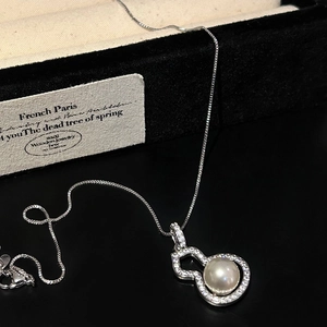 Detailed view of silver gourd pendant with sparkling zircons and a large white pearl